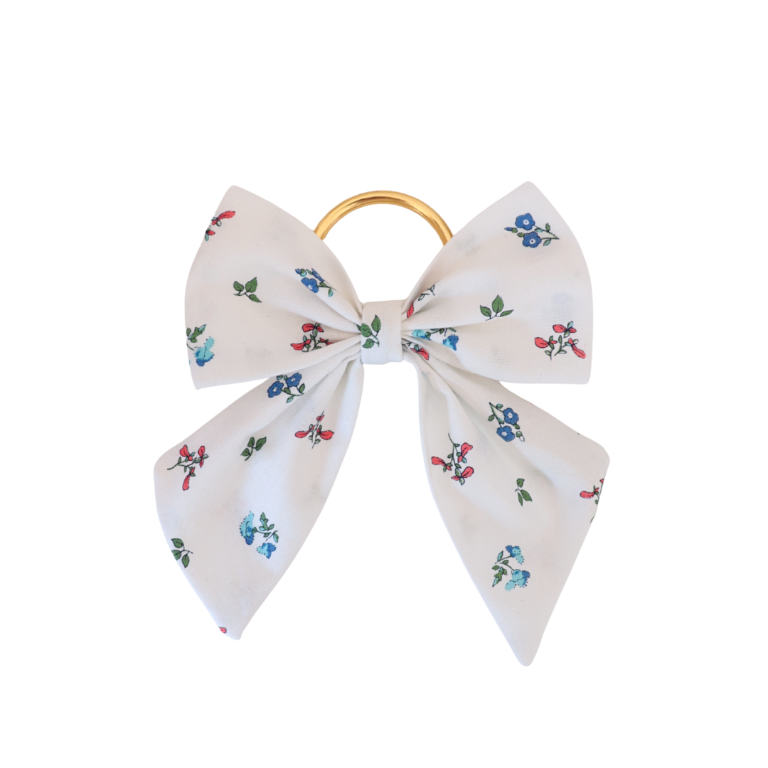 Floral-patterned hair bow with a gold clip on a white background