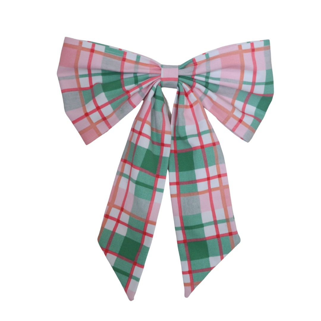 Plaid bow tie with pink, green, and white pattern on a white background