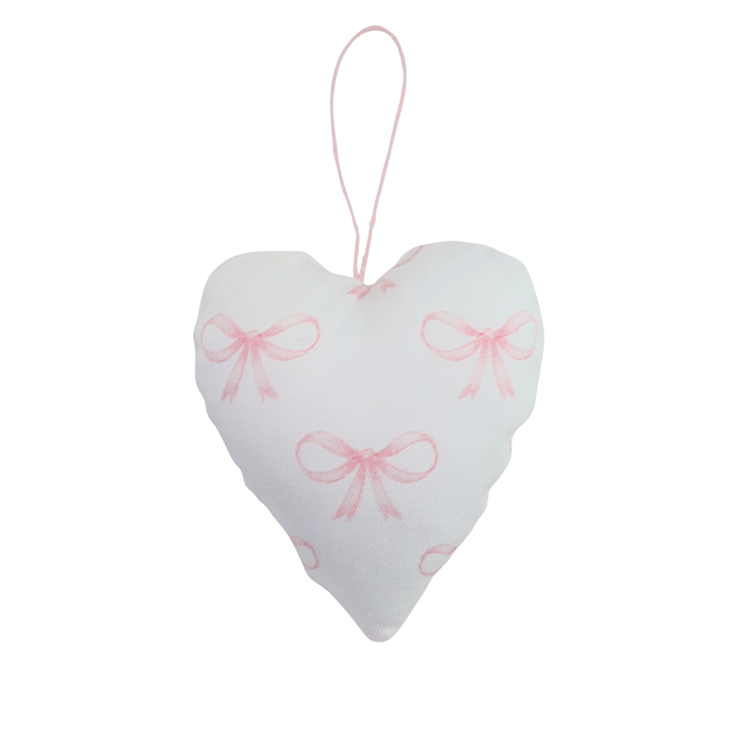 Heart-shaped decorative item with pink bows on a white background