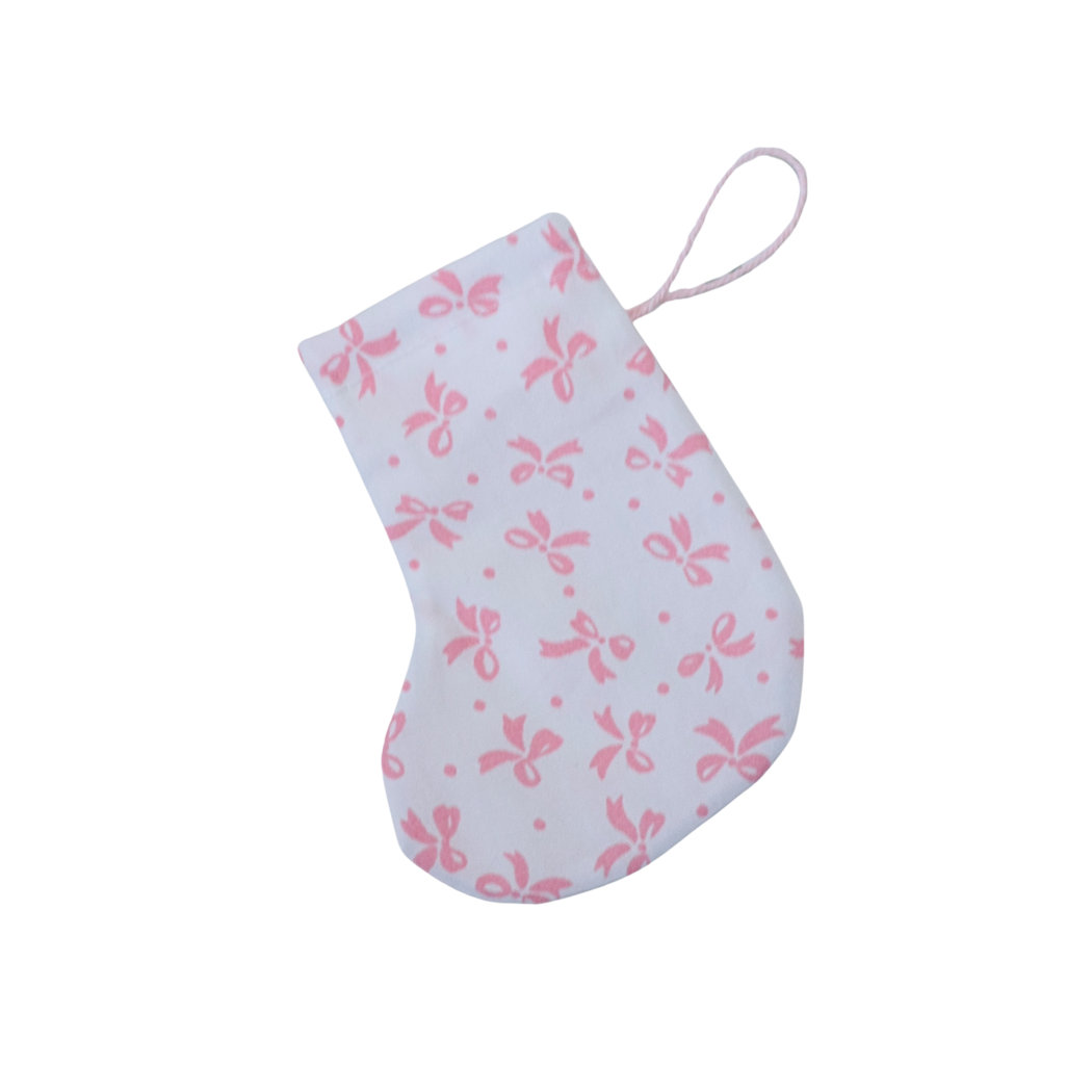 White baby bootie with pink bow pattern on a white background