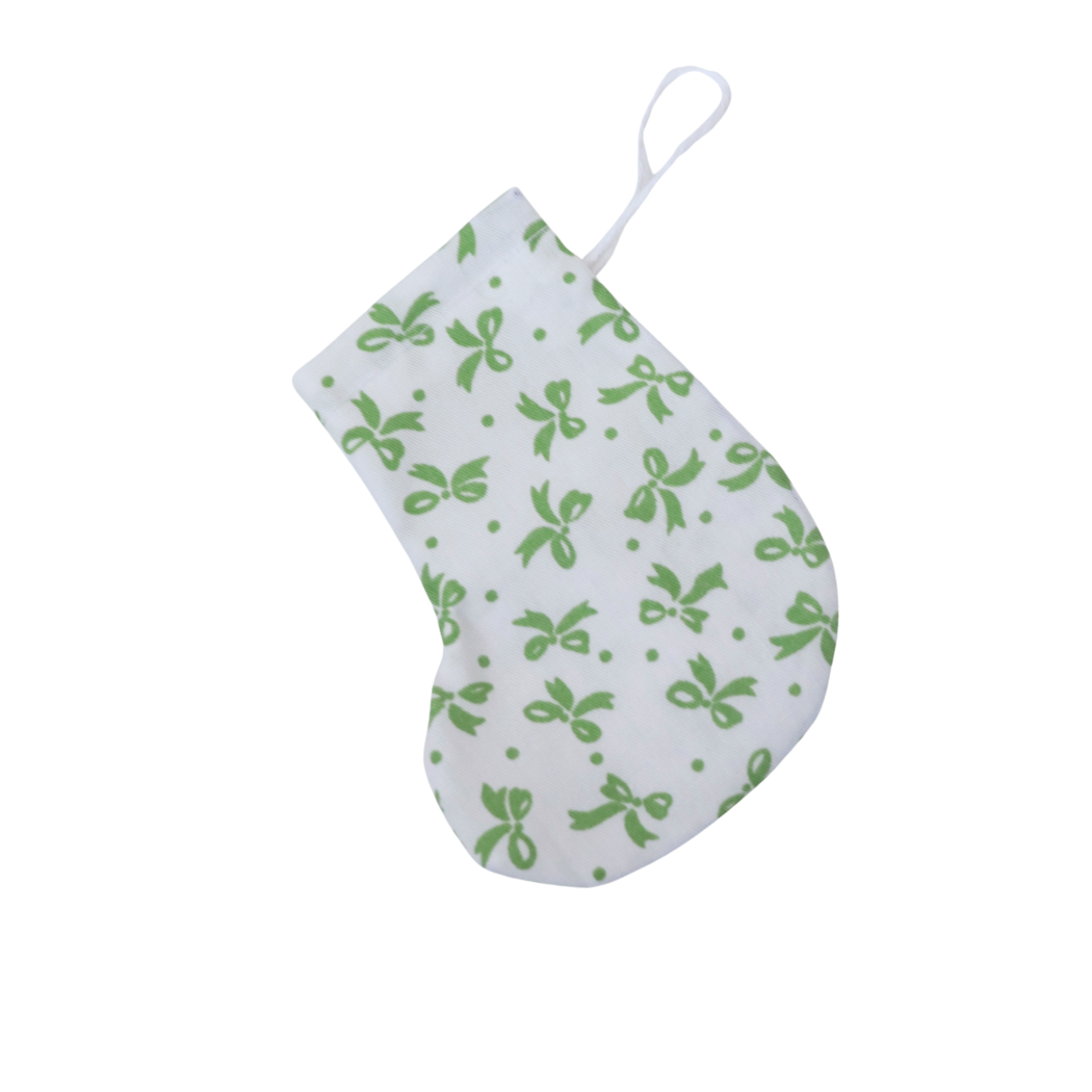 White baby bib with green bow pattern on a white background