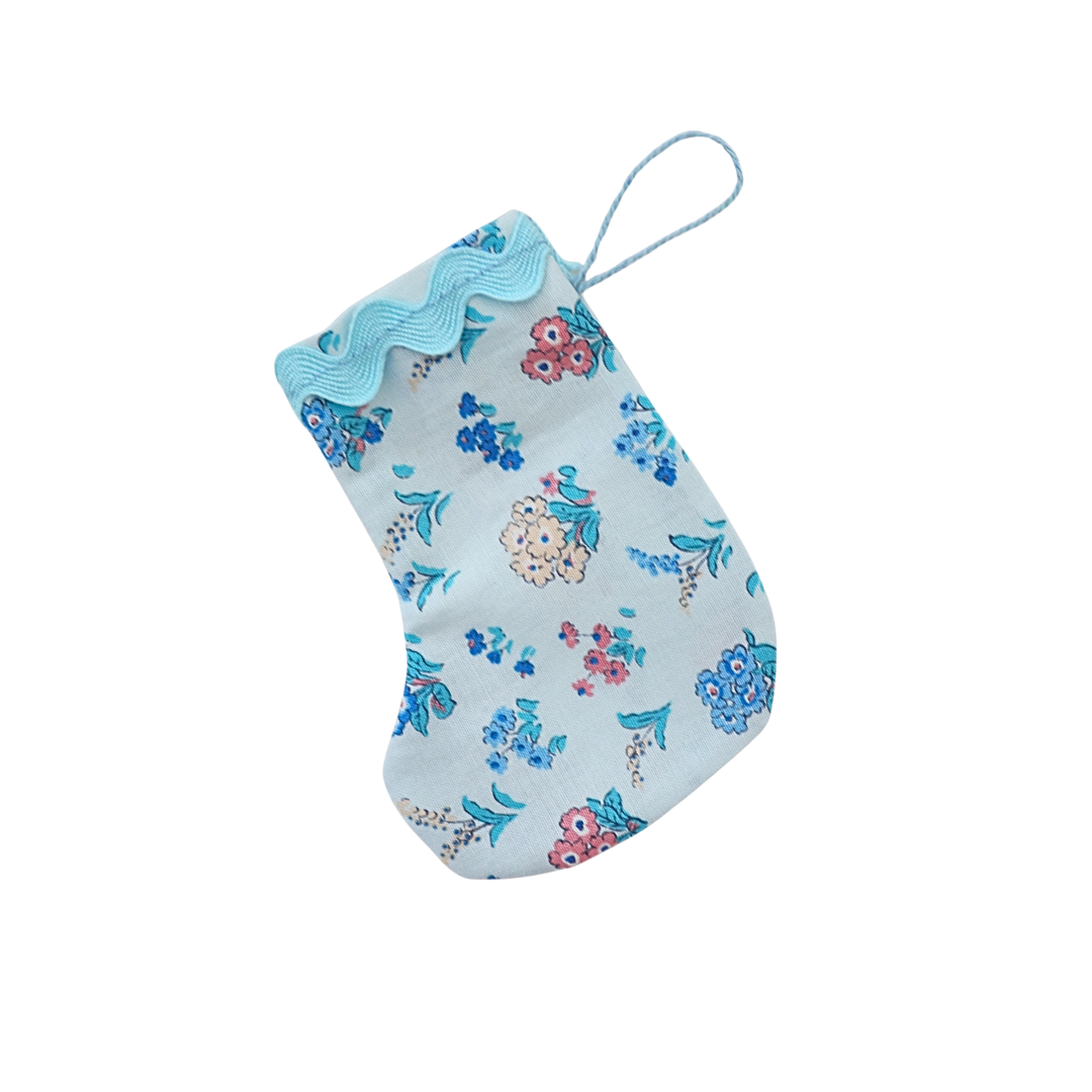 Floral-patterned stocking with blue trim on a white background