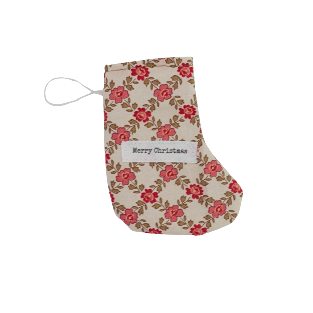 Floral-patterned Christmas stocking with 'Merry Christmas' tag on a white background