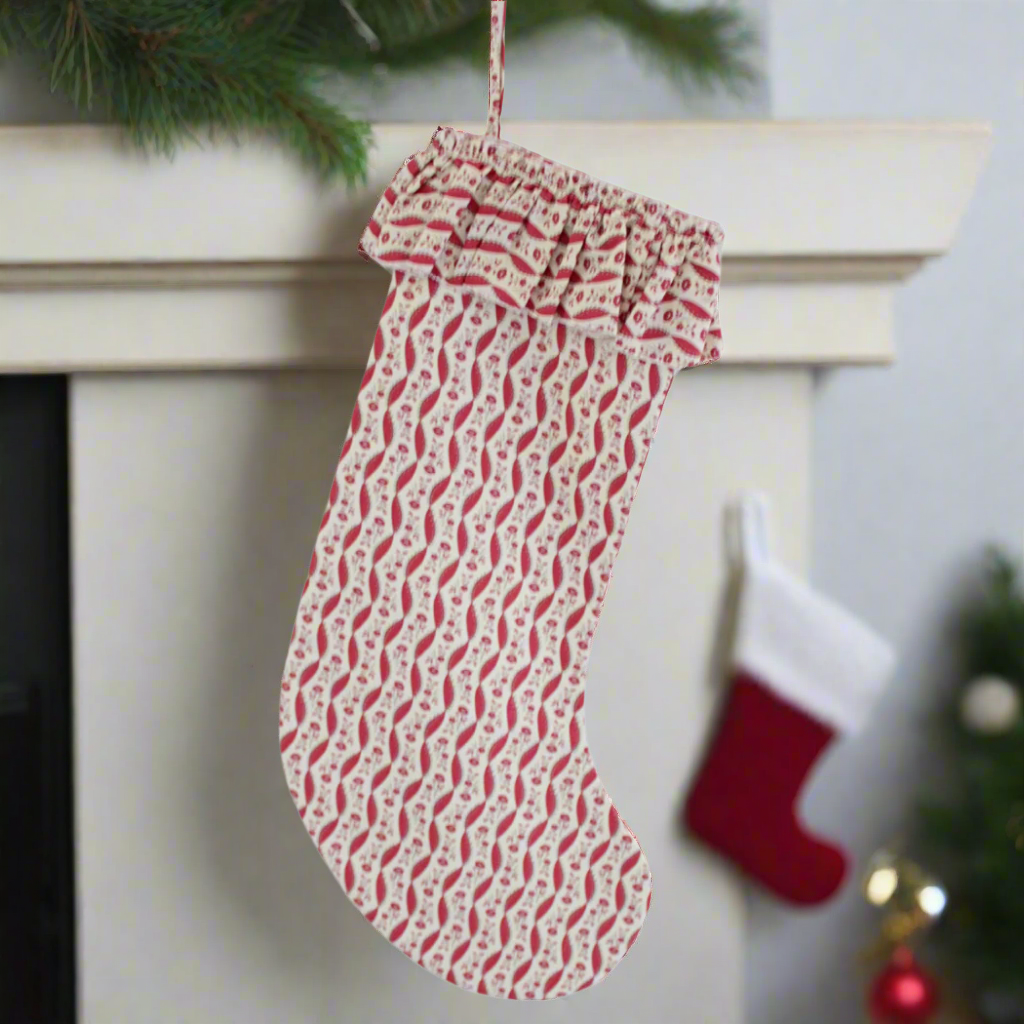 Red and white patterned Christmas stocking on a white background
