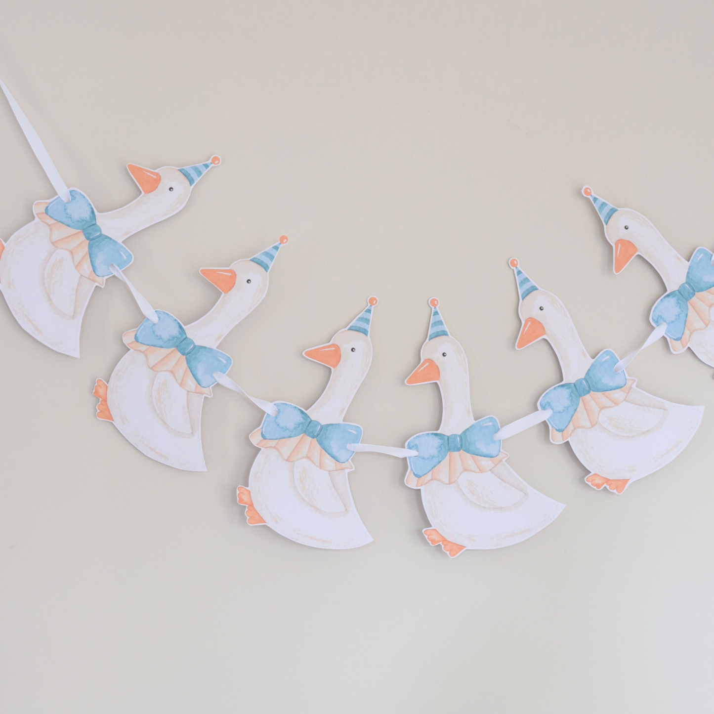 Decorative banner with cartoon ducks wearing party hats and bows on a plain background