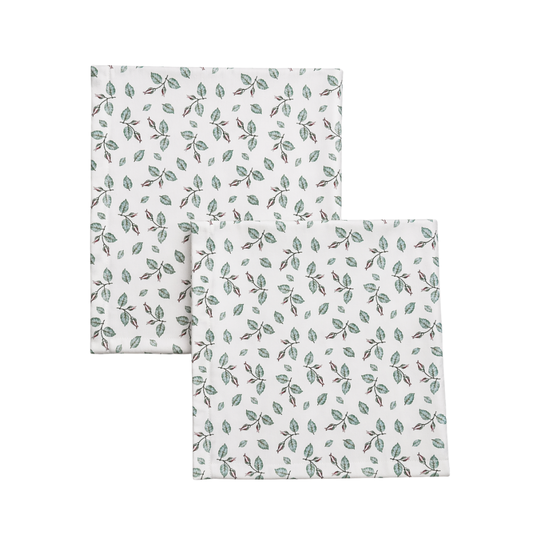 Two folded towels with a leaf pattern on a white background