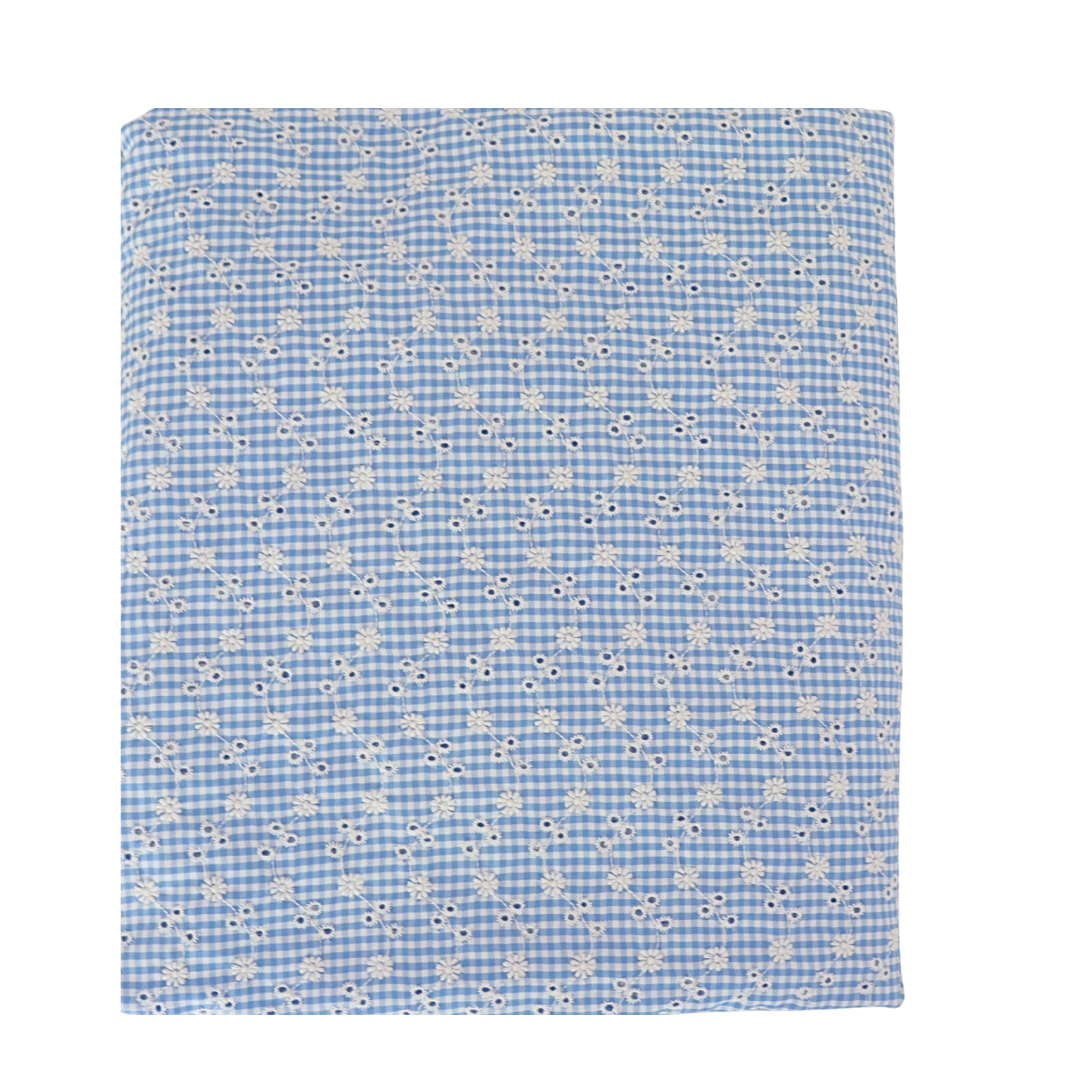 Blue checkered fabric with small white floral pattern on a white background