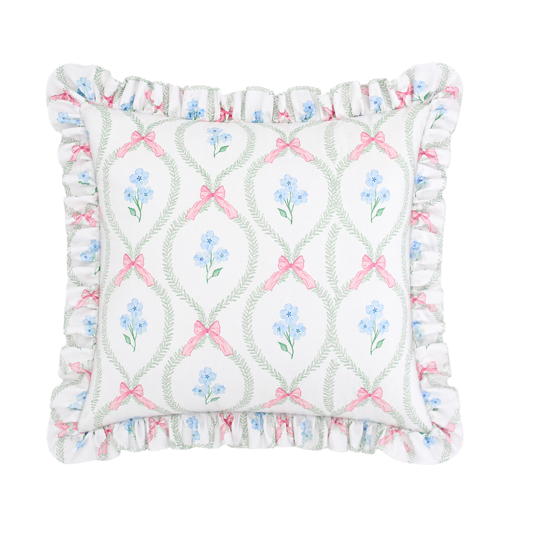 Decorative pillow with floral and bow pattern on a white background