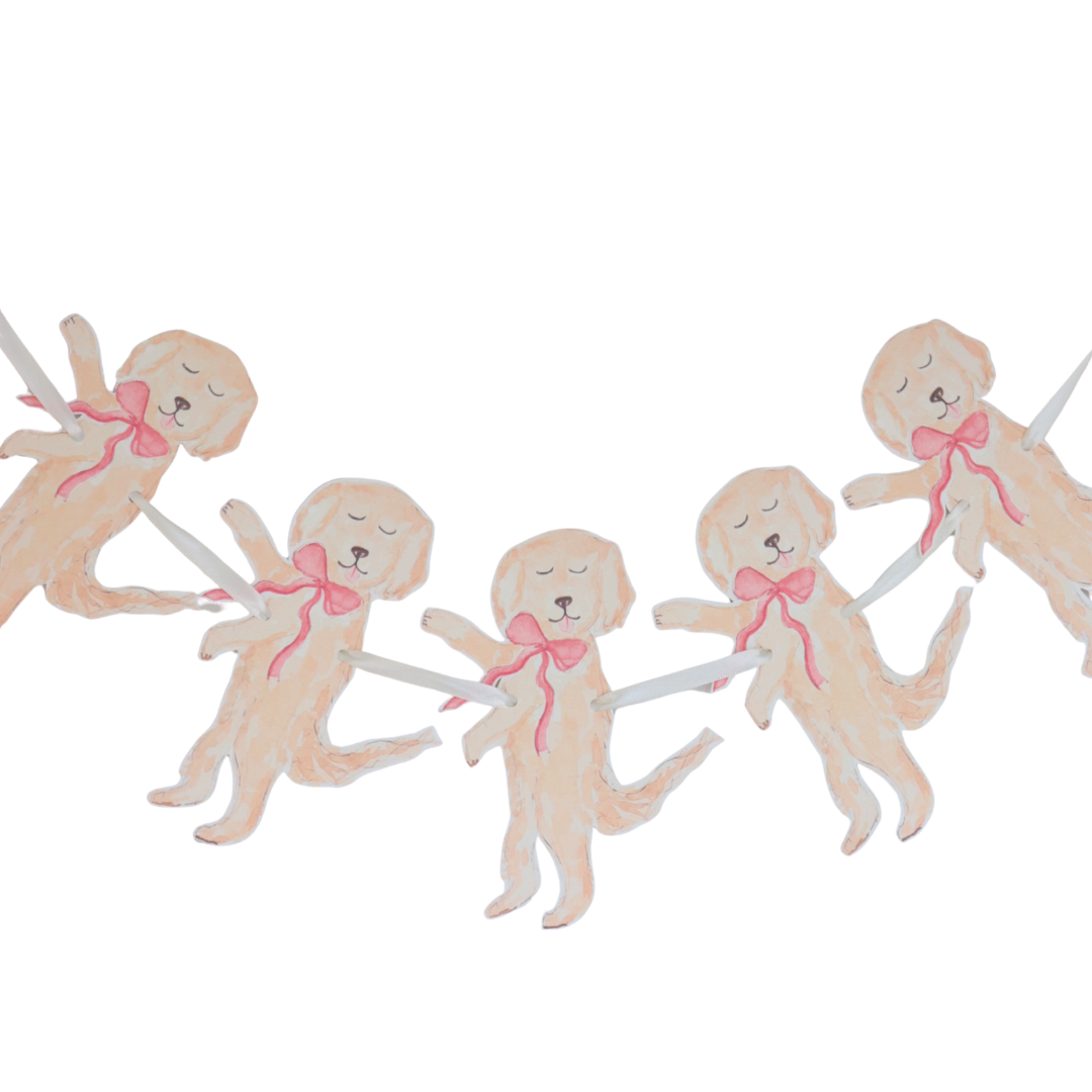 Decorative cake toppers shaped like dogs with pink bows on a white background