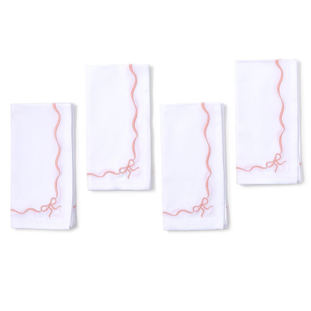 Set of four white napkins with red geometric patterns on a white background