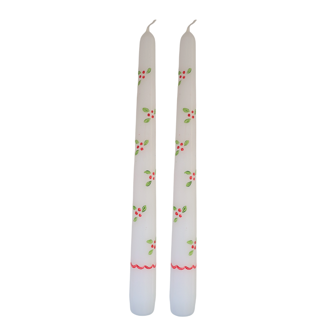 Two white candles with floral patterns on a white background