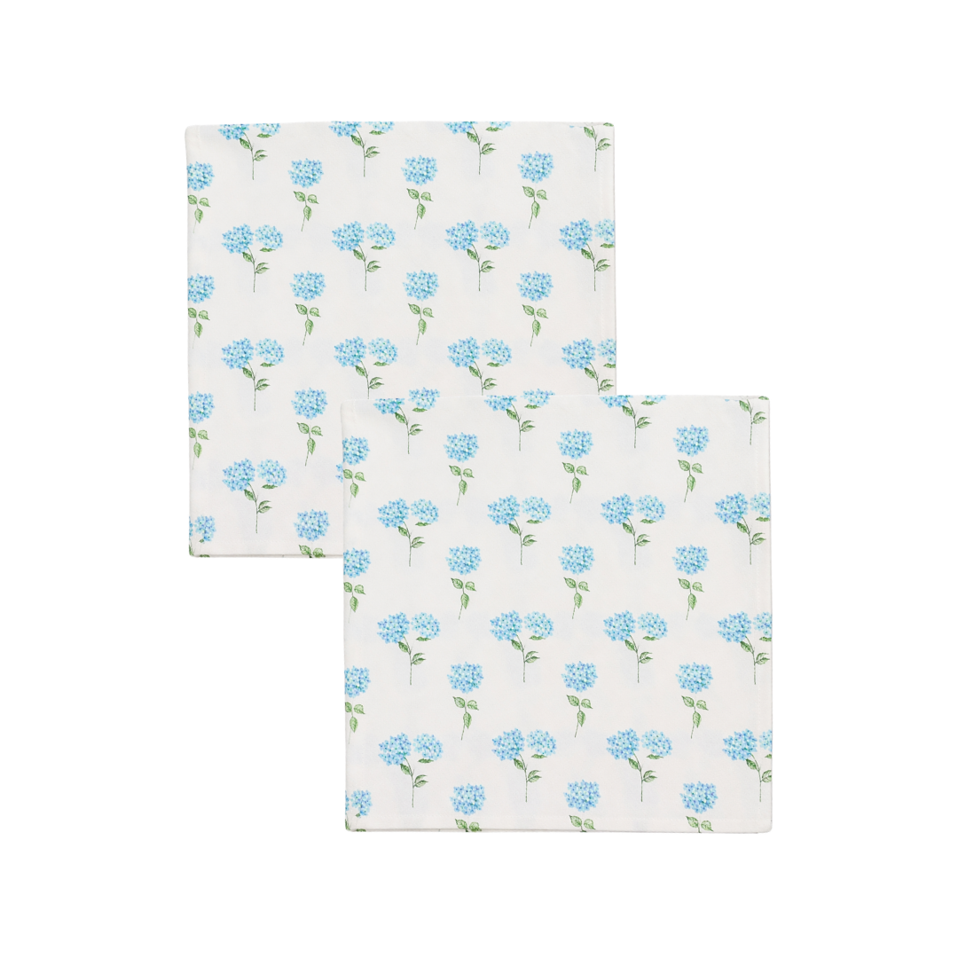 Two white napkins with blue floral patterns on a white background