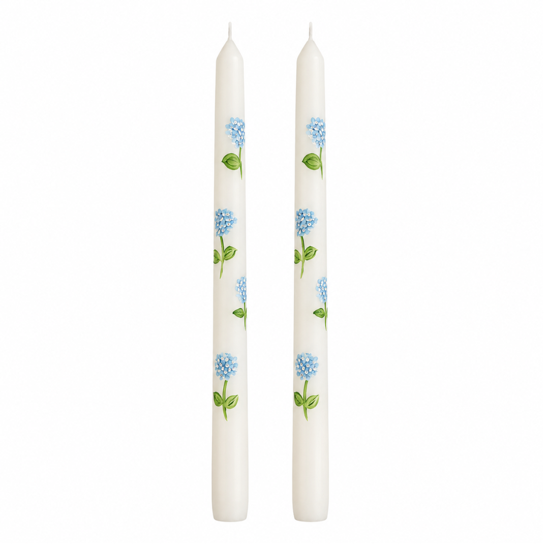 Two white candles with floral patterns on a white background