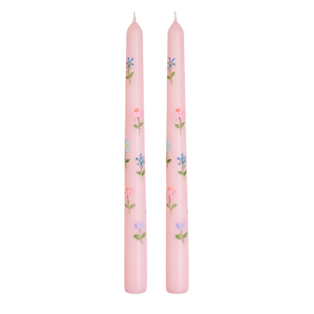 Two pink candles with floral patterns on a white background
