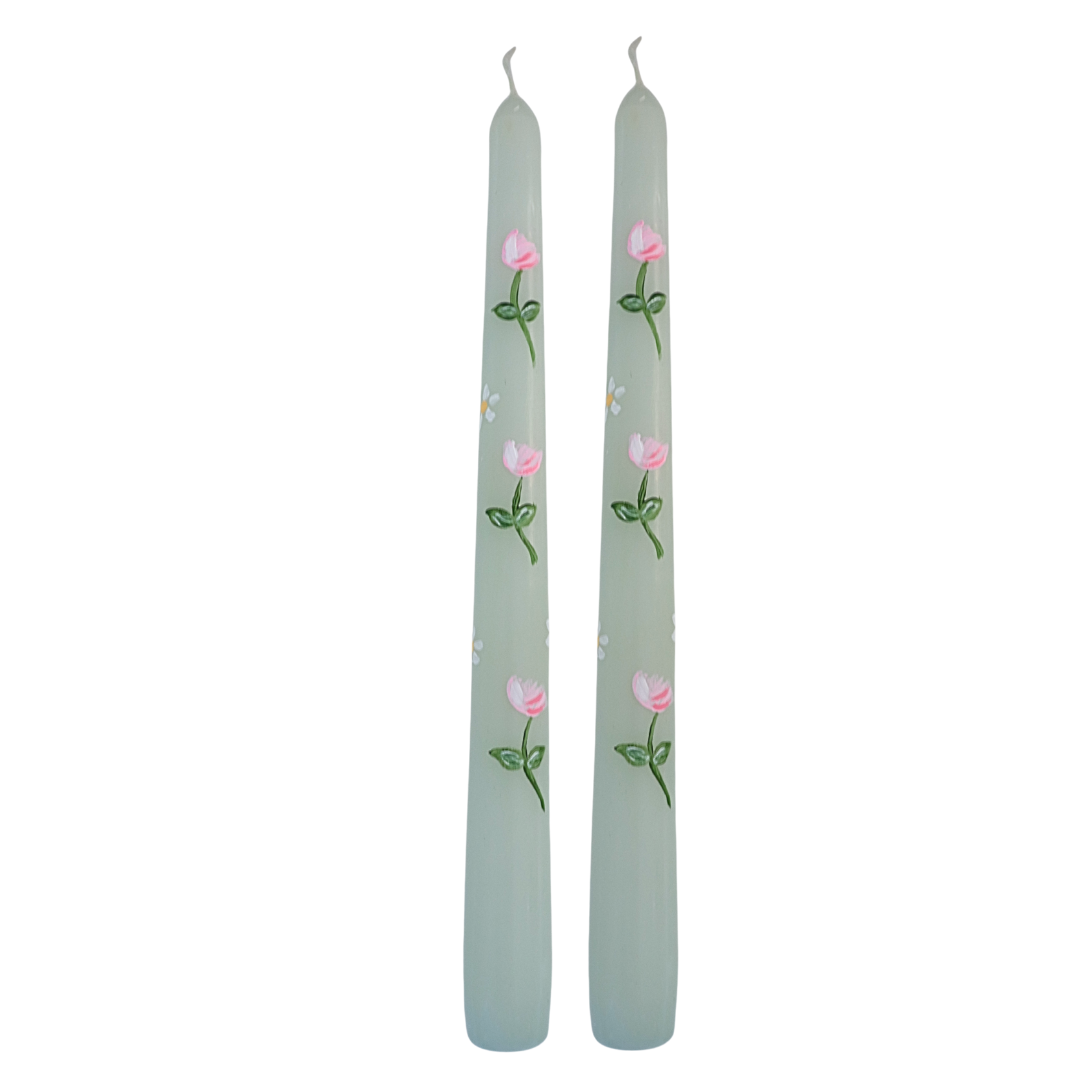 Two gray candles with floral designs on a white background
