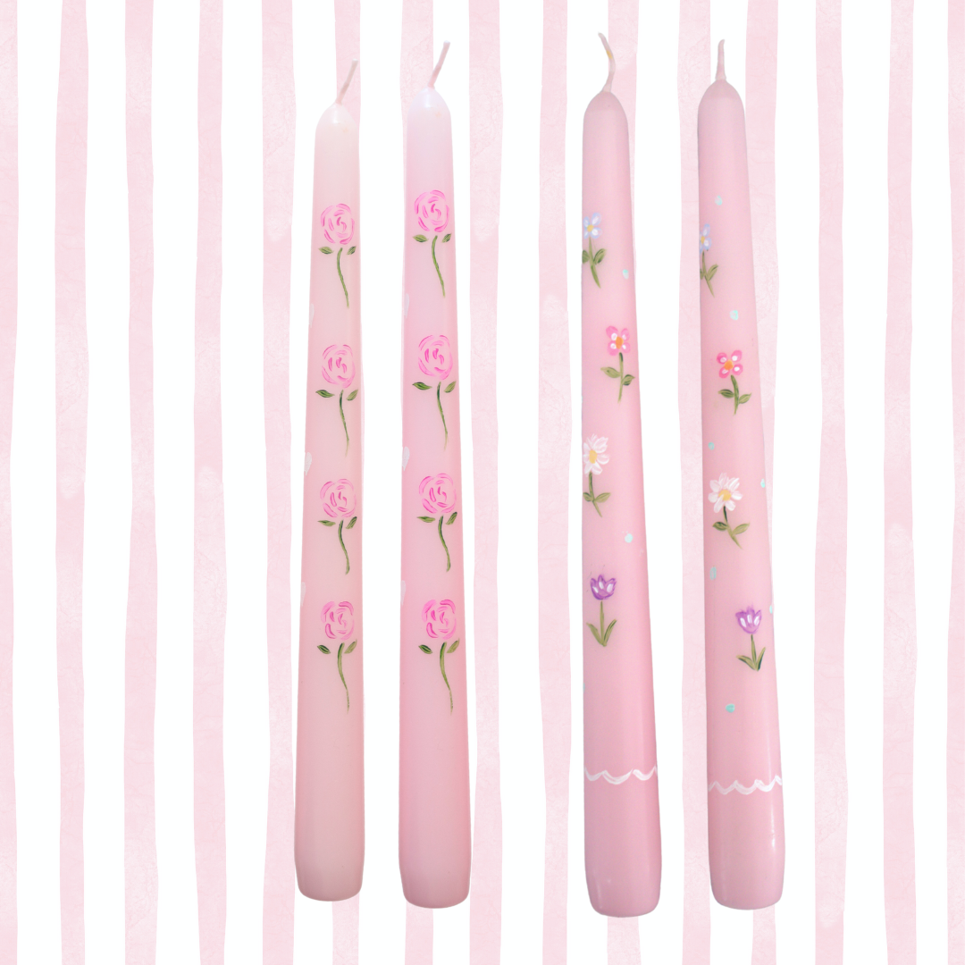 Set of pink candles with floral designs on a pink striped background
