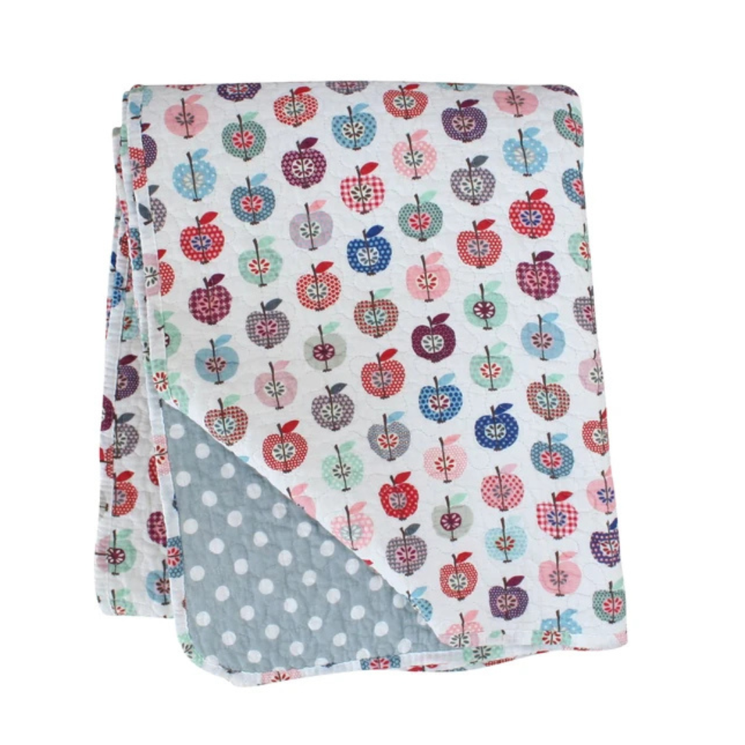 Flannel blanket with colorful apple pattern on one side and gray polka dot pattern on the other, folded on a white background.