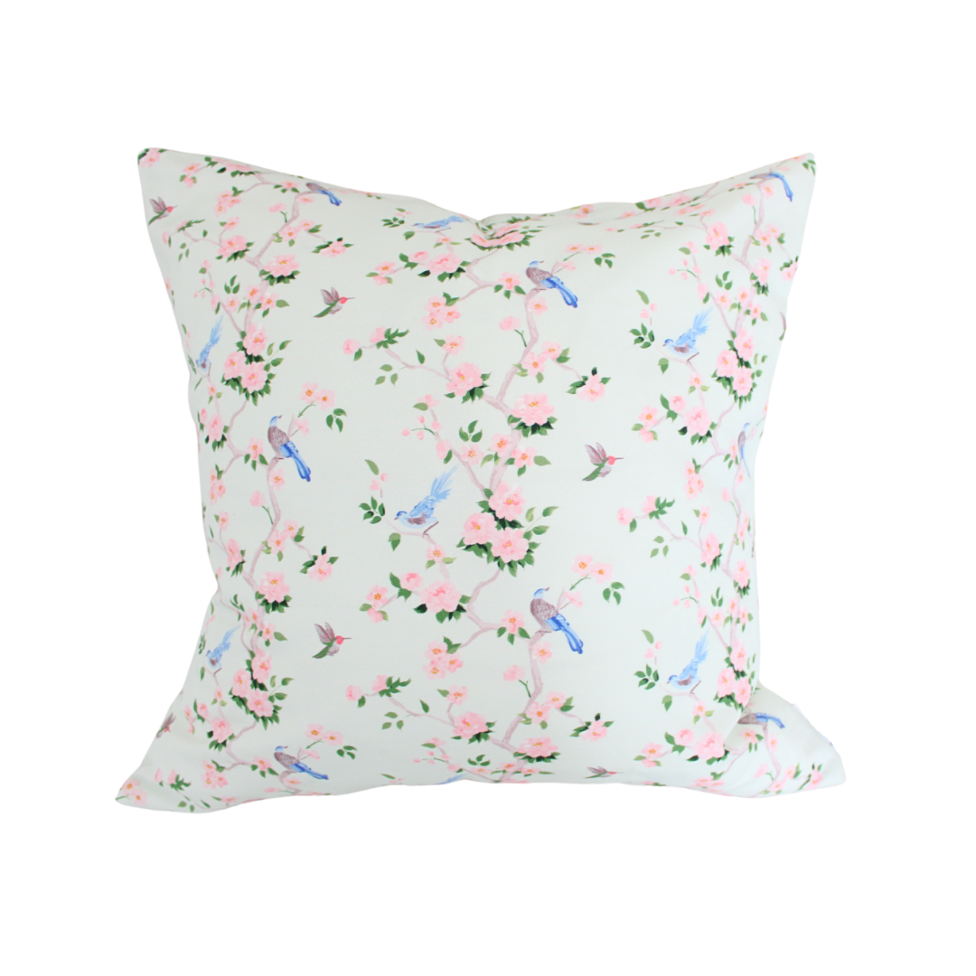 Decorative pillow with floral and bird pattern on a white background