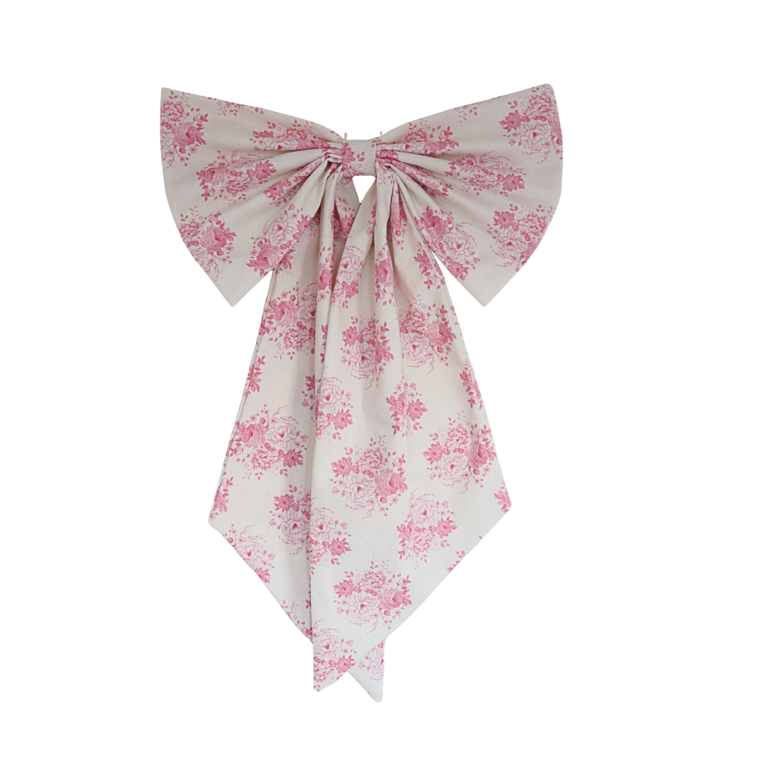 Floral patterned fabric bow on a white background