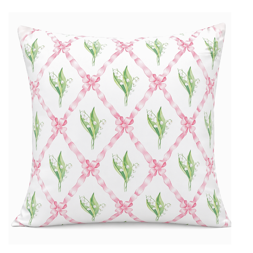 Decorative pillow with pink ribbons and green leaves pattern on a white background