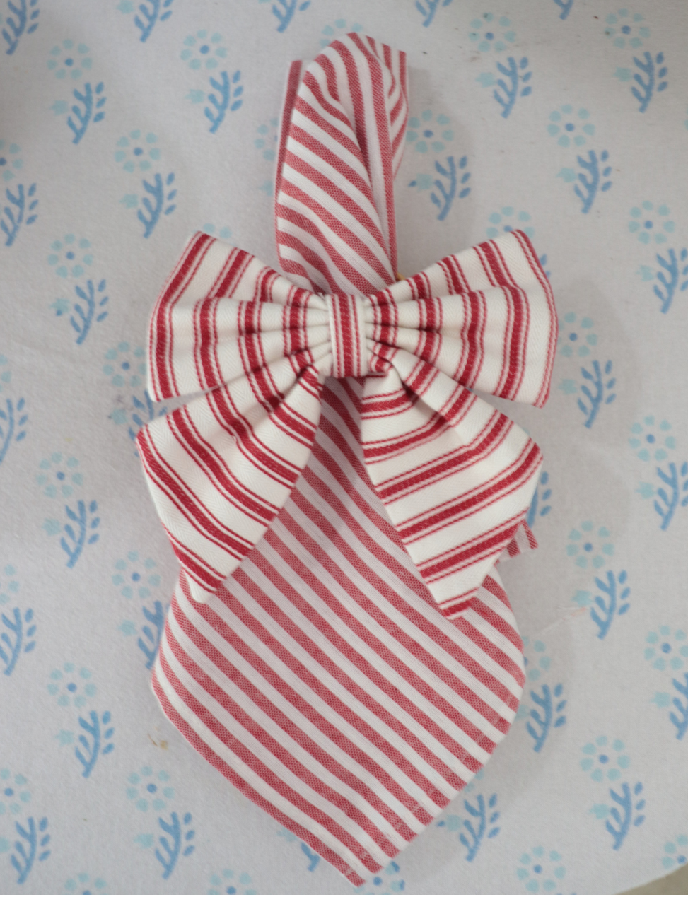 Red and white striped bow on a floral patterned background