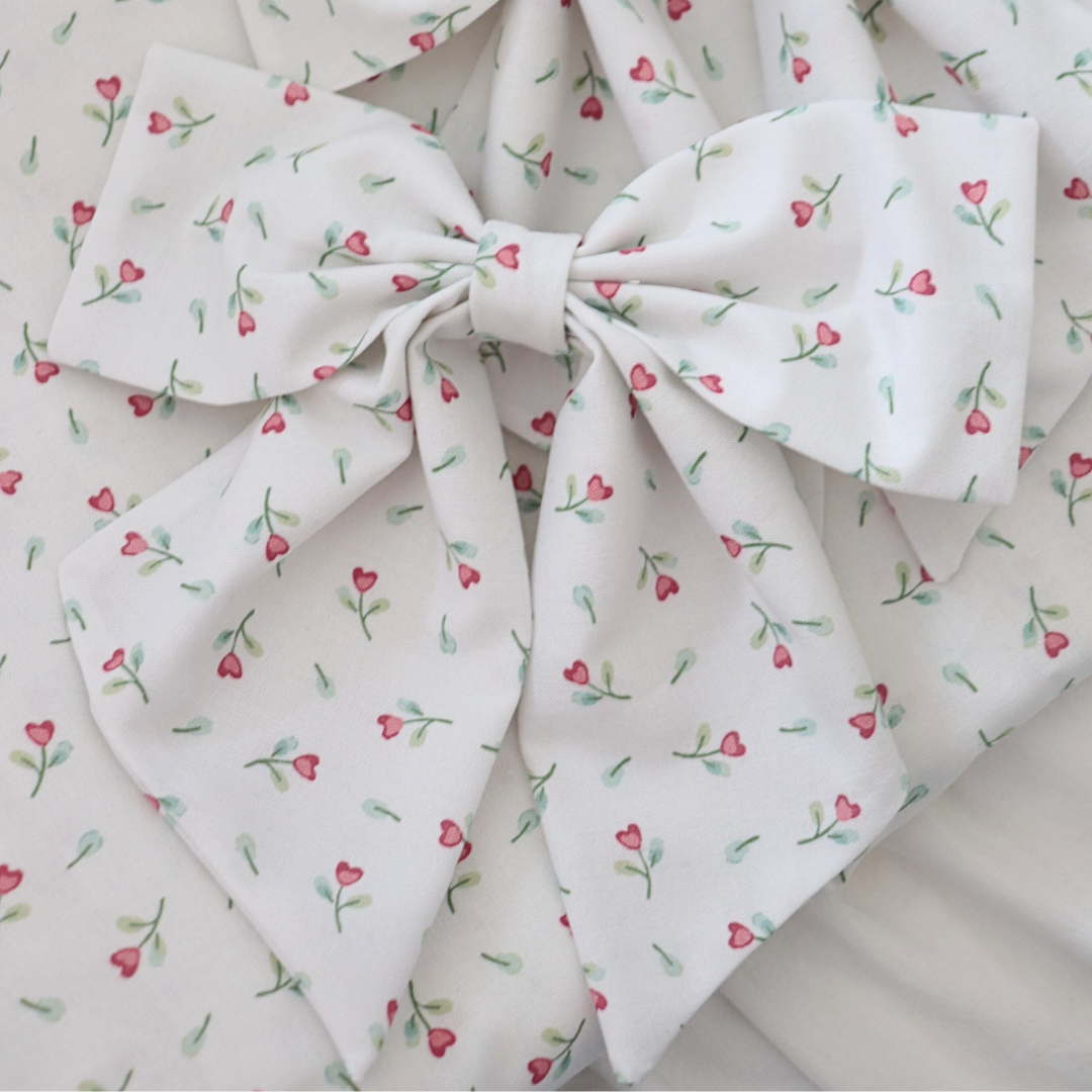 Fabric with a floral pattern and a large bow on a white background